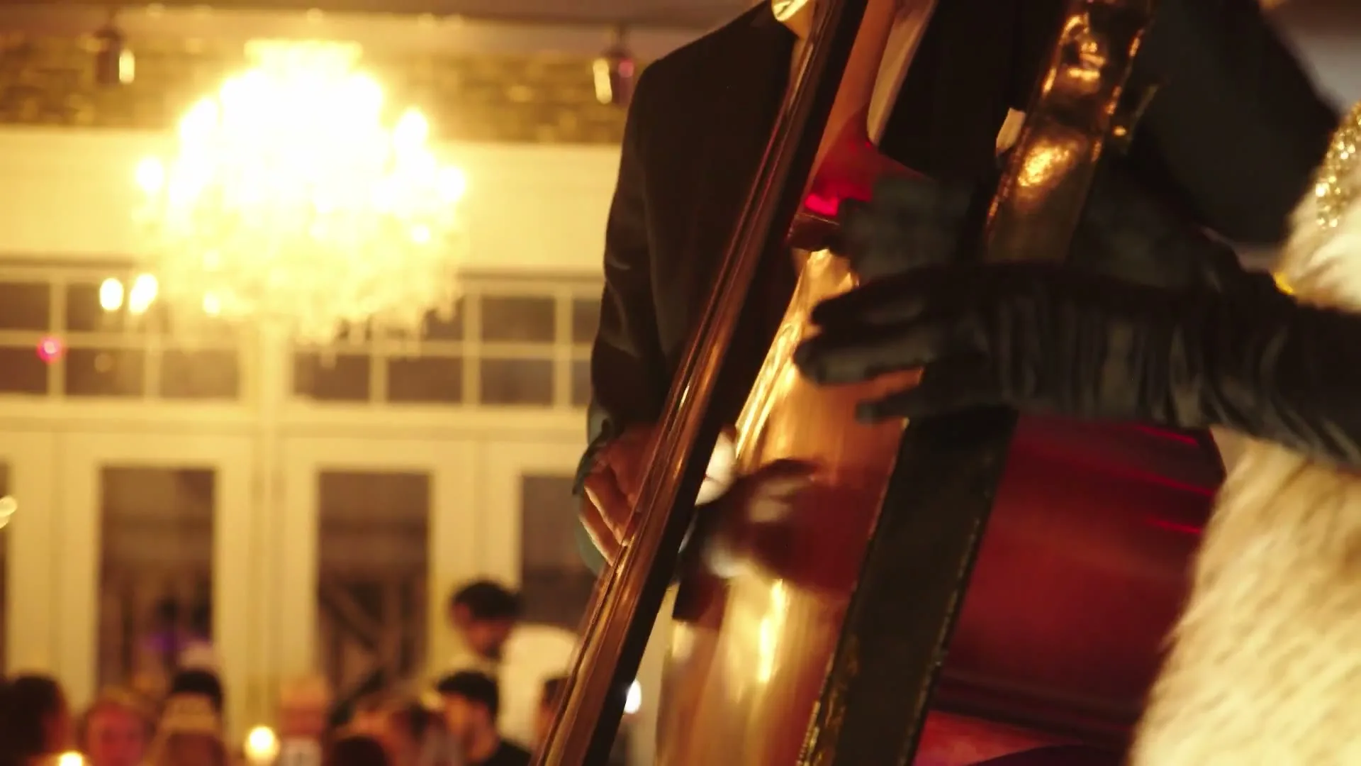 A bass player under the chandelier at the New Year's Eve party