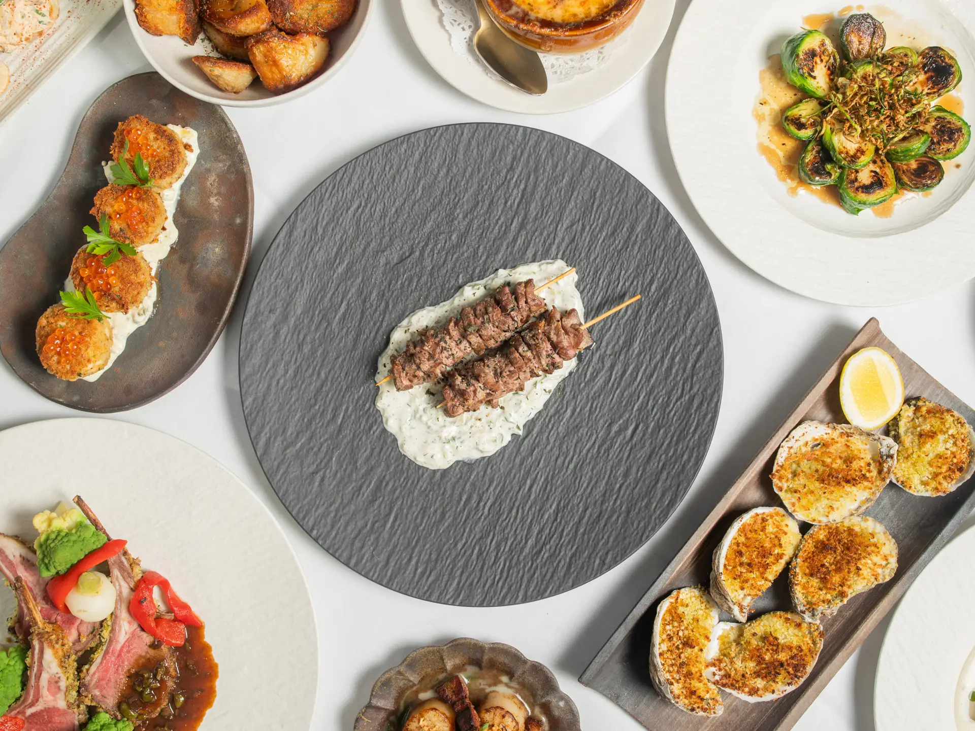 Steak skewers, crab cakes, baked oysters and sides from the kitchen, seen from above