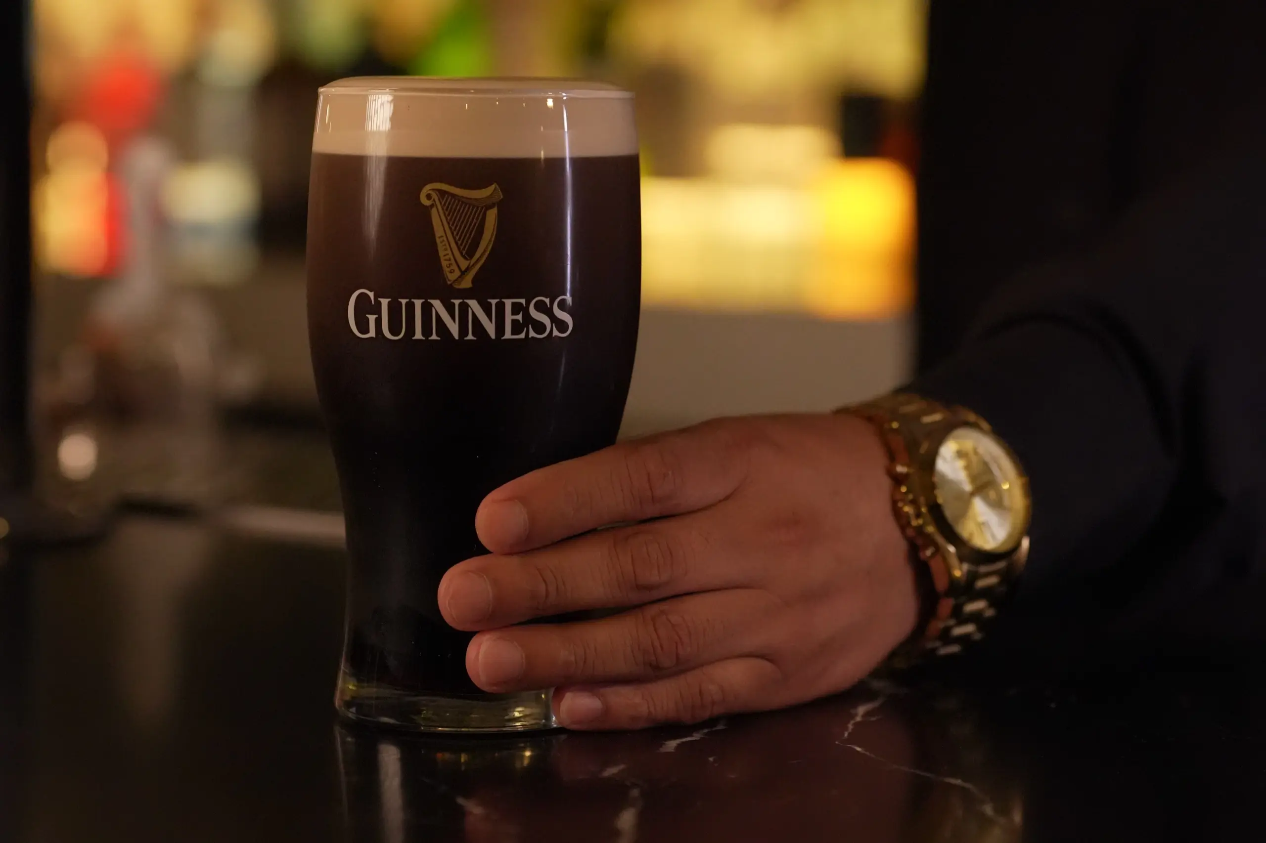 A bartender pouring a cocktail over ice