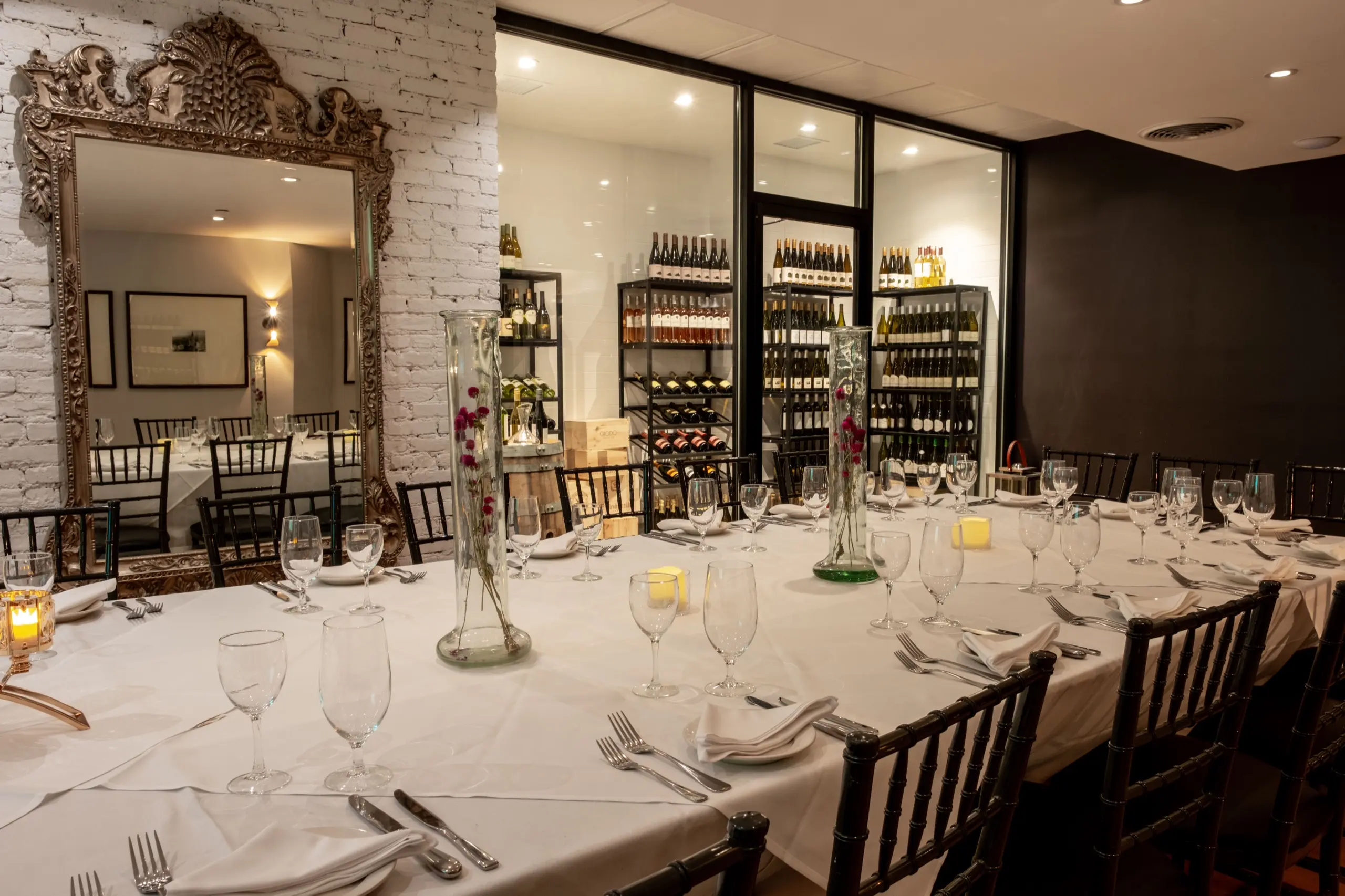 The Broadway Room set for a long-table dinner, the wine wall behind